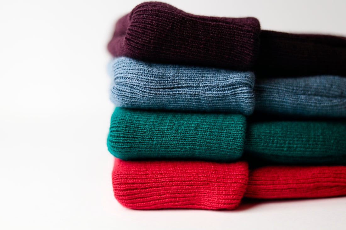 a stack of folded sweaters sitting on top of each other