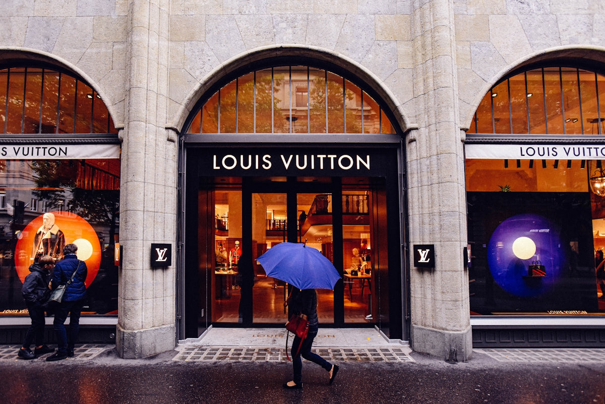 a person walking down the sidewalk with an umbrella