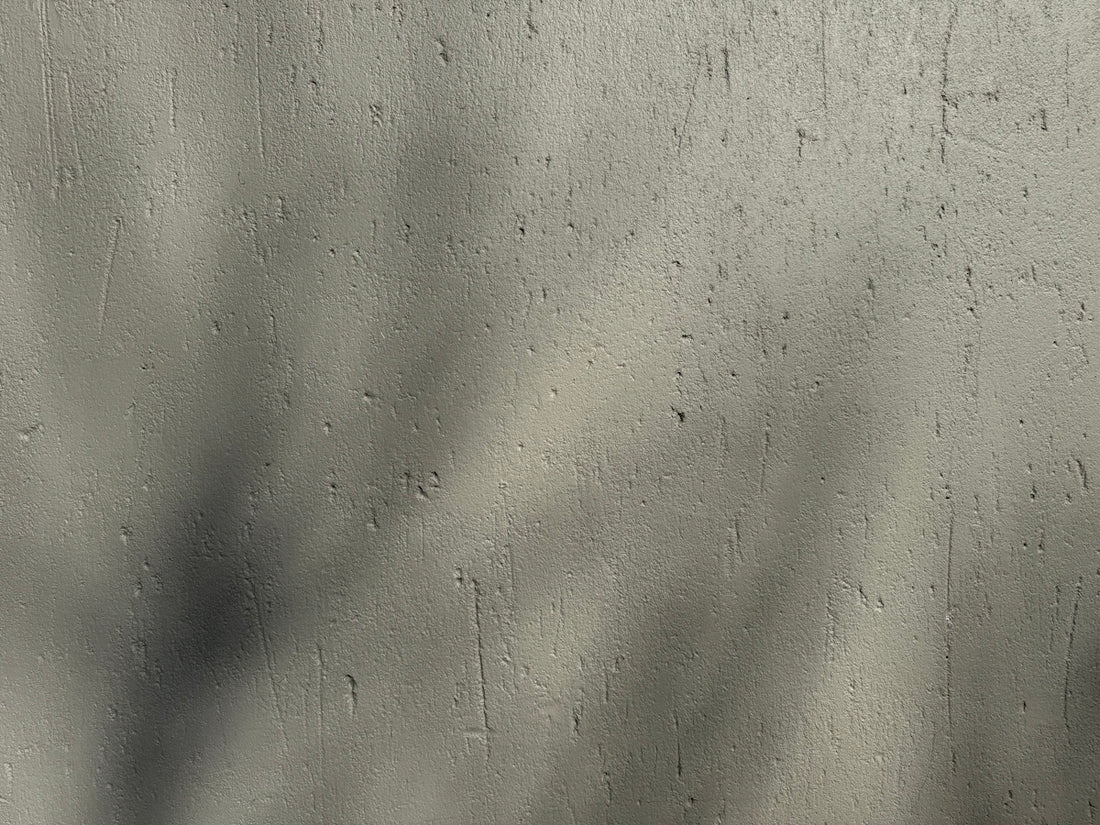 Shadows fall across a textured, gray surface.